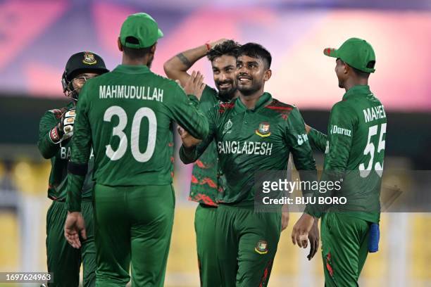 Bangladesh's Sheikh Mehedi Hasan celebrates with teammates the wicket of Sri Lanka's Dhananjaya de Silva during a warm-up match between Bangladesh...