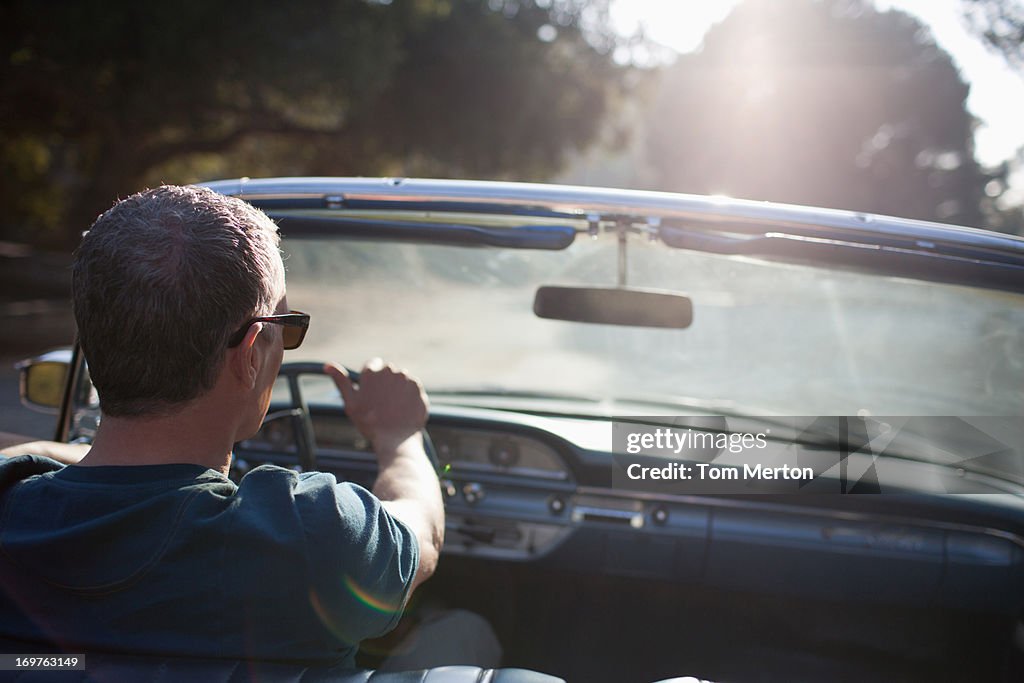 Man driving convertible car