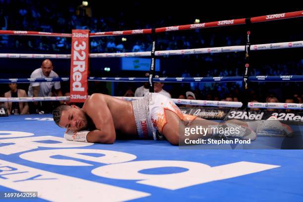 Joe Joyce lies down in the florr after Zhilei Zhang KO as the referee makes the countdown during the WBO Interim World Heavyweight Title fight...