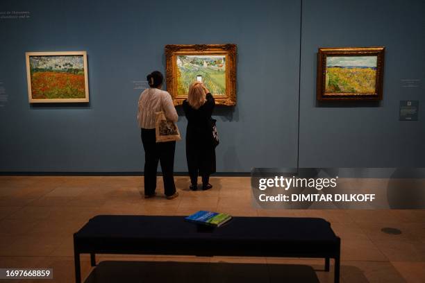 Visitors look at paintings by Vincent Van Gogh during the press preview of the exhibition "Van Gogh in Auvers-sur-Oise, last months" at Orsay Museum...