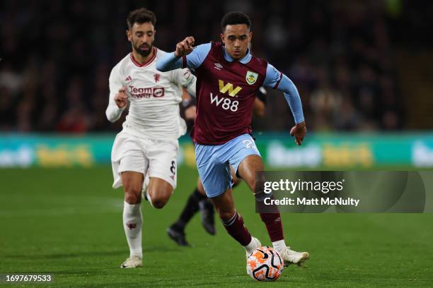 Aaron Ramsey of Burnley dribbles with the ball past Bruno Fernandes of Manchester United during the Premier League match between Burnley FC and...