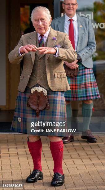 Britain's King Charles III, wearing a kilt and sporran, reacts during his visit to the Global Underwater Hub in Westhill, eastern Scotland, September...