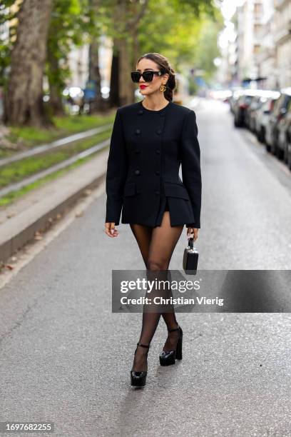 Tamara Kalinic wears black double breasted blazer, tights, bag, earrings, sunglasses outside Dolce & Gabbana during the Milan Fashion Week -...