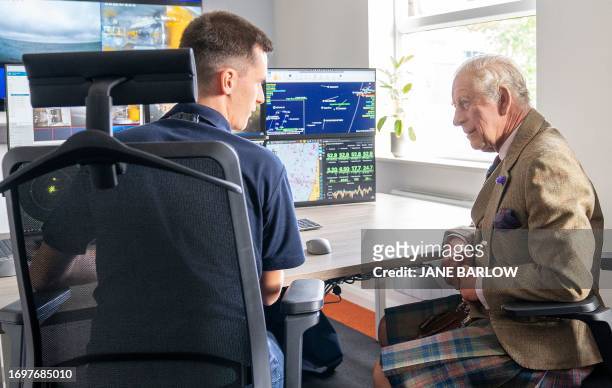 Britain's King Charles III helps to operate an underwater ROV during his visit to the Global Underwater Hub in Westhill, eastern Scotland, September...
