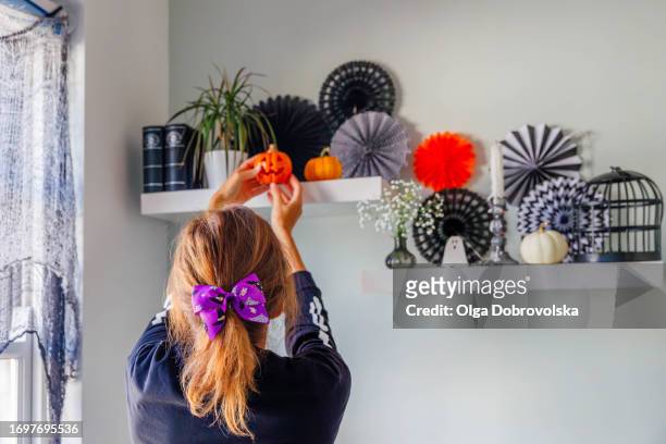 rear view of a woman decorating a home for halloween - hair bow stock pictures, royalty-free photos & images