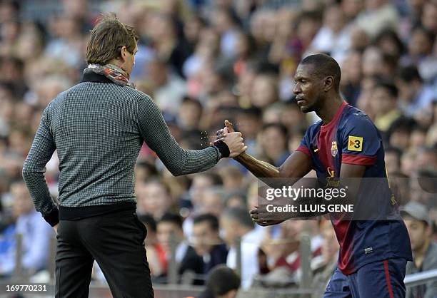 Barcelona's French defender Eric Abidal shakes hands with Barcelona's coach Tito Vilanova before entering the field during the Spanish league...