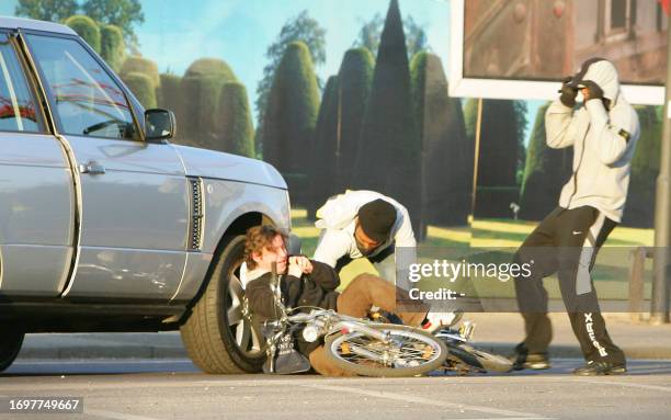 Scene two of a sequence of pictures shows two masked men knocking a cyclist to the ground and stealing his bag during a street robbery, in front of...