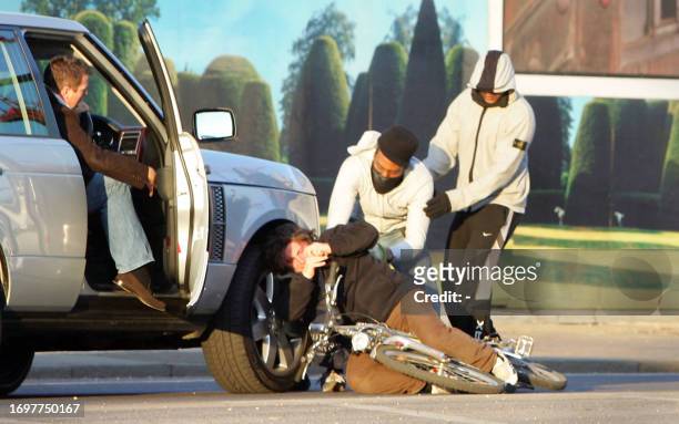 Scene three of a sequence of pictures shows two masked men knocking a cyclist to the ground and stealing his bag during a street robbery, in front of...