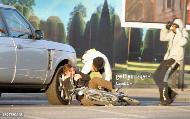 Scene one of a sequence of pictures shows two masked men knocking a cyclist to the ground and stealing his bag during a street robbery, in front of...