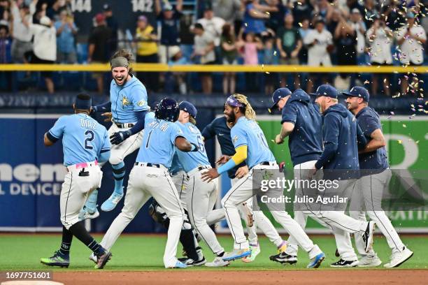 Josh Lowe of the Tampa Bay Rays celebrates with teammates after hitting a walk-off RBI single in the ninth inning to defeat the Toronto Blue Jays 7-6...