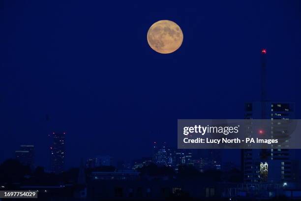 Supermoon is visible above the London skyline. The moon will be near its closest approach to the Earth and may look slightly larger and brighter than...