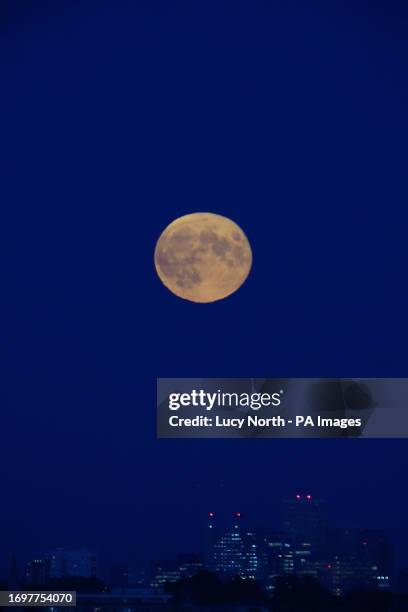 Supermoon is visible above the London skyline. The moon will be near its closest approach to the Earth and may look slightly larger and brighter than...