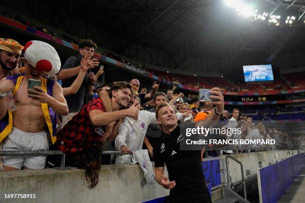 New Zealand's fly-half Damian McKenzie takes selfies with rugby fans after the during the France 2023 Rugby World Cup Pool A match between New...