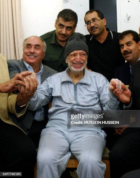 -- This handout file picture released by the Palestinian Authority's press office 28 October 2004 shows ailing leader Yasser Arafat smiling among his...
