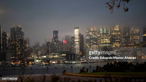 The New York skyline is covered with clouds during a coastal storm on September 29, 2023 as seen from Weehawken, New Jersey. Flash flooding is...