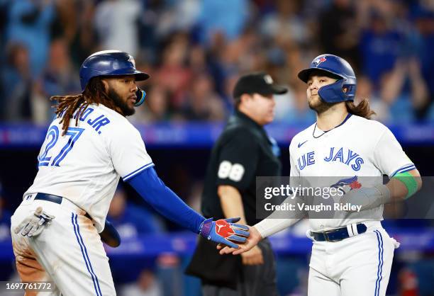 Vladimir Guerrero Jr. #27 celebrates with Bo Bichette of the Toronto Blue Jays after scoring on a two RBI single by Cavan Biggio in the sixth inning...