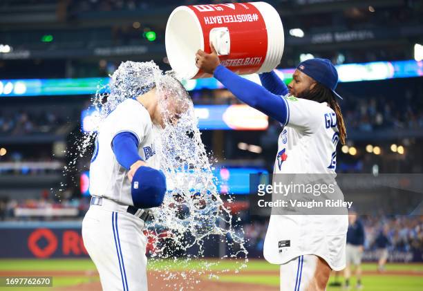 Matt Chapman of the Toronto Blue Jays is doused with water by Vladimir Guerrero Jr. #27 following a win against the Tampa Bay Rays at Rogers Centre...