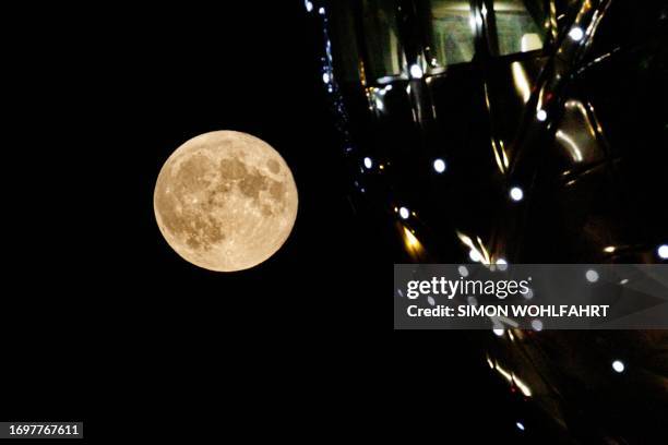 The last supermoon of the year, also known as the Harvest Moon is seen rising on top of the Atomium monument in Brussels on September 29, 2023. The...