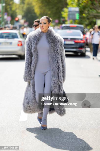 Ginevra Mavilla wears grey faux fur coat, overall, heels outside Ferragamo during the Milan Fashion Week - Womenswear Spring/Summer 2024 on September...