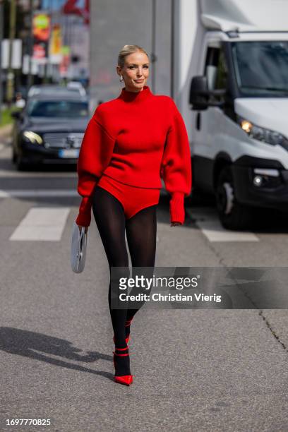 Leonie Hanne wears red slip, tights, turtleneck jumper, white bag, heels outside Ferragamo during the Milan Fashion Week - Womenswear Spring/Summer...