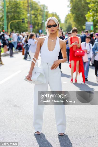 Vanessa Hong wears white top, pants, bag outside Ferragamo during the Milan Fashion Week - Womenswear Spring/Summer 2024 on September 23, 2023 in...