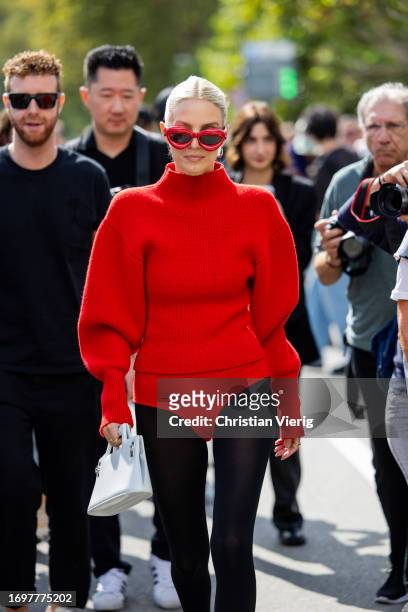 Leonie Hanne wears red slip, tights, turtleneck jumper, white bag, sunglasses outside Ferragamo during the Milan Fashion Week - Womenswear...