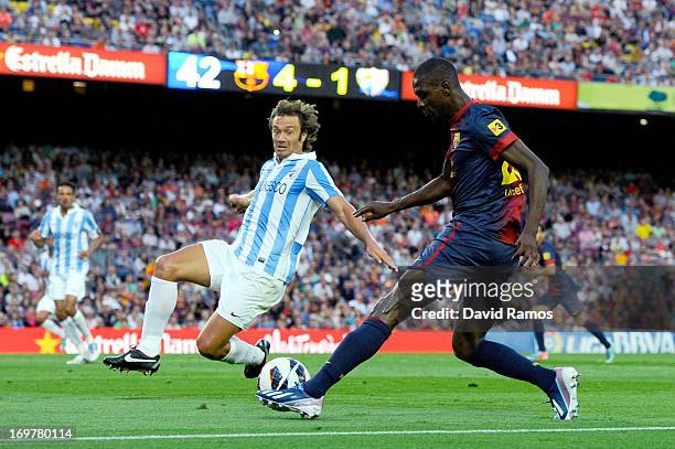 Eric Abidal of FC Barcelona duels for the ball with Diego Lugano of Malaga CF during the La Liga match between FC Barcelona and Malaga CF at Camp Nou...
