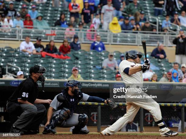 Ryan Doumit of the Minnesota Twins hits an two run triple as Kelly Shoppach of the Seattle Mariners and umpire Tim McClelland look on during the...