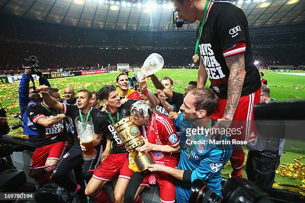 Anatoliy Tymoshchuk of Bayern Muenchen holds the trophy as he celebrates with team mates after the DFB Cup Final match between FC Bayern Muenchen and...