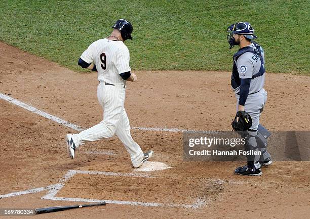 Kelly Shoppach of the Seattle Mariners looks on as Ryan Doumit of the Minnesota Twins crosses home plate during the sixth inning of the game on June...