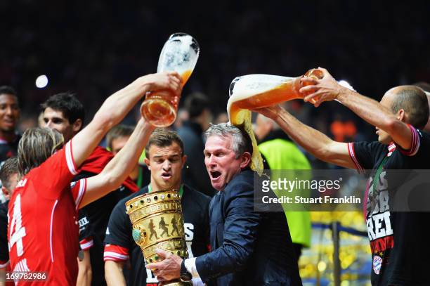 Jupp Heynckes head coach of Bayern Muenchen is showered with beer by Anatoliy Tymoshchuk and Arjen Robben as he celebrates victory in his last match...