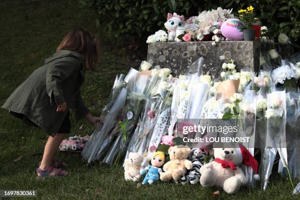 Child lays a flower during a tribute to late 3 year old Lisa, in front of the city hall of Conches-en-Ouches, northwestern France, on September 30,...