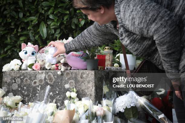 Woman lays a flower during a tribute to late 3 year old Lisa, in front of the city hall of Conches-en-Ouches, northwestern France, on September 30,...