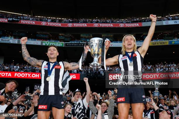 Jamie Elliott and Darcy Moore of the Magpies celebrate with the premiership cup during the 2023 AFL Grand Final match between the Collingwood Magpies...