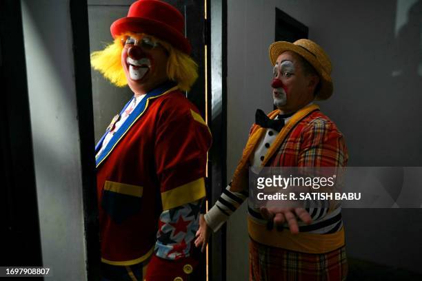 Men dressed as clowns wait backstage before their performance in the International Clown Festival in Chennai on September 30, 2023.
