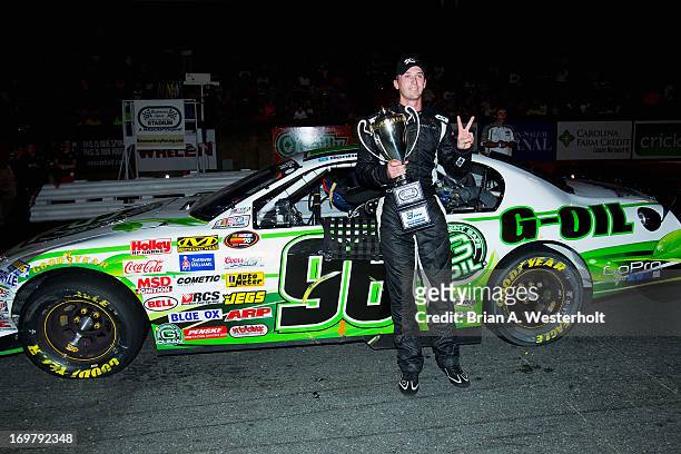 Ben Kennedy, driver of the Emco Gears/Mac Tools/Mechanix Wear Chevrolet, poses in front of his car with the trophy after winning the NASCAR K&N Pro...