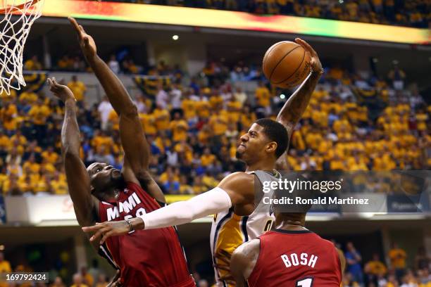 Paul George of the Indiana Pacers dunks the ball against Joel Anthony and Chris Bosh of the Miami Heat in Game Six of the Eastern Conference Finals...