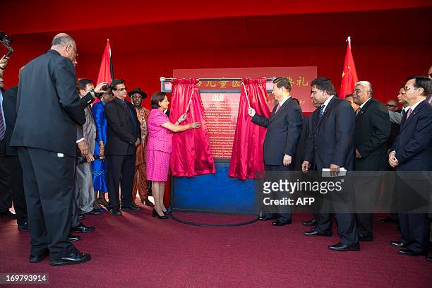 China's President Xi Jinping and Prime Minister of Trinidad and Tobago Kamla Persad-Bissessar unveil a plaque at the site of the Couva Children´s...