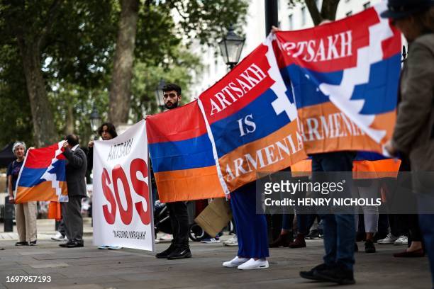 Armenians hold placards and national flags during a demonstration outside Downing Street in London on September 30, 2023 to protest against...