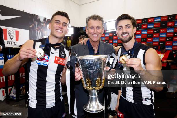 Nick Daicos and Josh Daicos of the Magpies pose for a photo with their dad Peter Daicos and the Premiership Cup during the 2023 AFL Grand Final match...