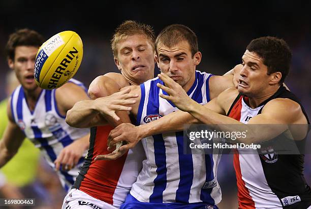 Ben Cunnington of the Kangaroos contests for the ball against Sebastian Ross and Leigh Montagna during the round ten AFL match between the North...