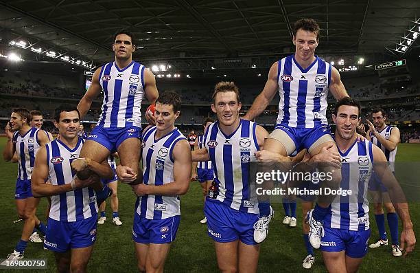 Daniel Wells of the Kangaroos gets carried off by Lindsay Thomas and Scott Thompson for his 200th game and and Brent Harvey gets carried off by Drew...