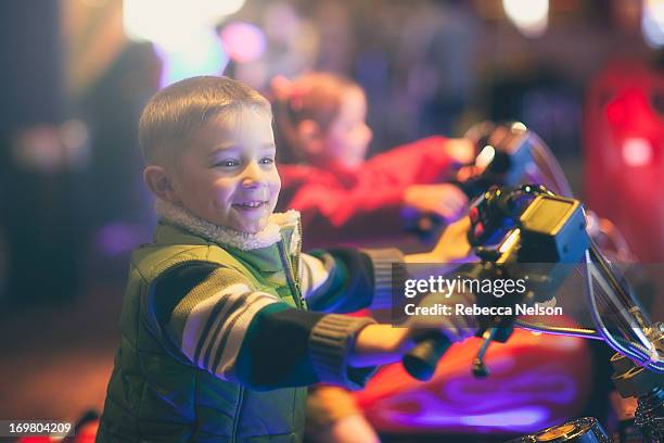 boy on toy motorcycle at arcade - arcade stockfoto's en -beelden