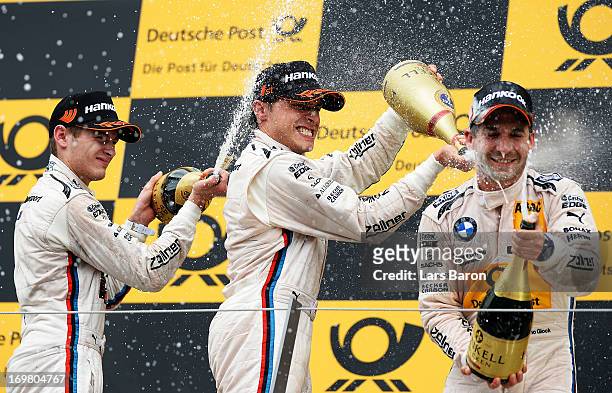 First placed Bruno Spengler of Canada and BMW Team Schnitzer celebrates with second placed Marco Wittmann of Germany and BMW Team MTEK and third...