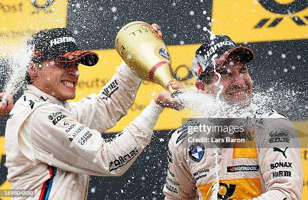 Bruno Spengler of Canada and BMW Team Schnitzer celebrates with third placed Timo Glock of Germany and BMW Team MTEK after winning the third round of...