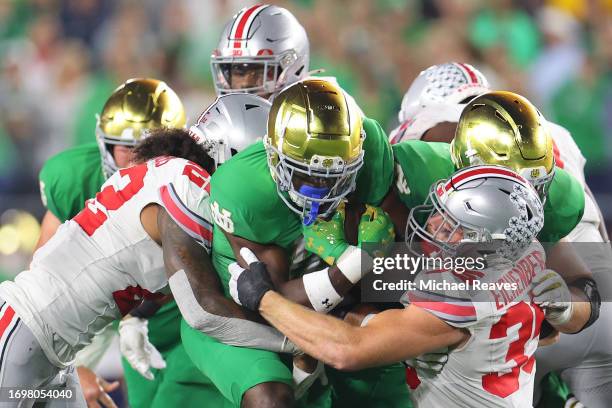 Audric Estime of the Notre Dame Fighting Irish is tackled by Tommy Eichenberg of the Ohio State Buckeyes during the second half at Notre Dame Stadium...