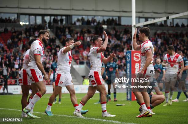 Lewis Dodd celebrates scoring their sides first try with team-mates Alex Walmsley, Louie McCarthy-Scarsbrook and Jon Bennison of St.Helens during the...