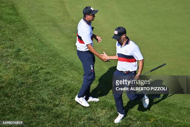Non-playing US golfer, Rickie Fowler congratulates US golfer, Brian Harman as he leaves the 7th green during his four-ball match on the second day of...