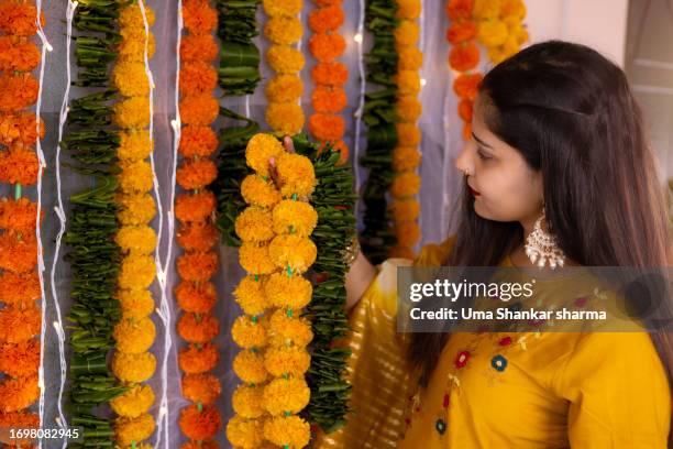 beautiful lady looking at marigold garland. - preparation of gudi padwa festival stock pictures, royalty-free photos & images