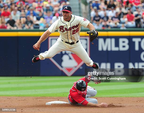 Dan Uggla of the Atlanta Braves turns a double play against Steve Lombardozzi of the Washington Nationals at Turner Field on June 2, 2013 in Atlanta,...